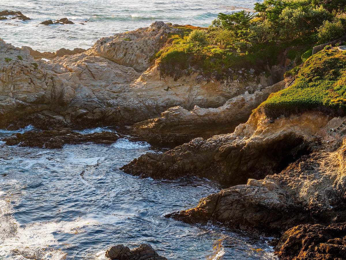cliff aerial photo of rocks near body of water ocean