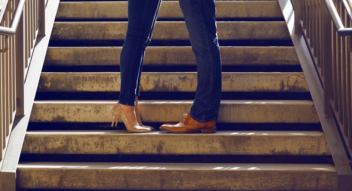 couple two person wearing blue jeans standing on gray concrete stair handrail