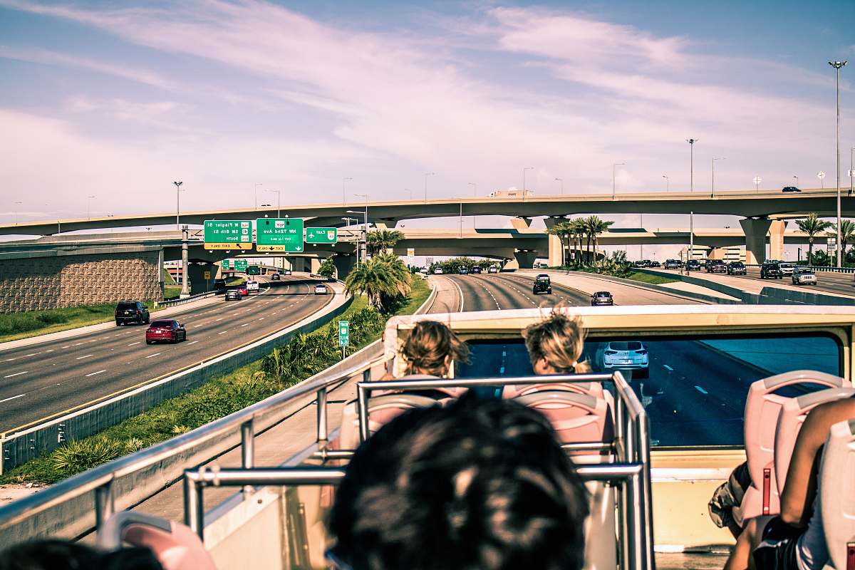 freeway group of people sitting on top of double-decker bus overpass