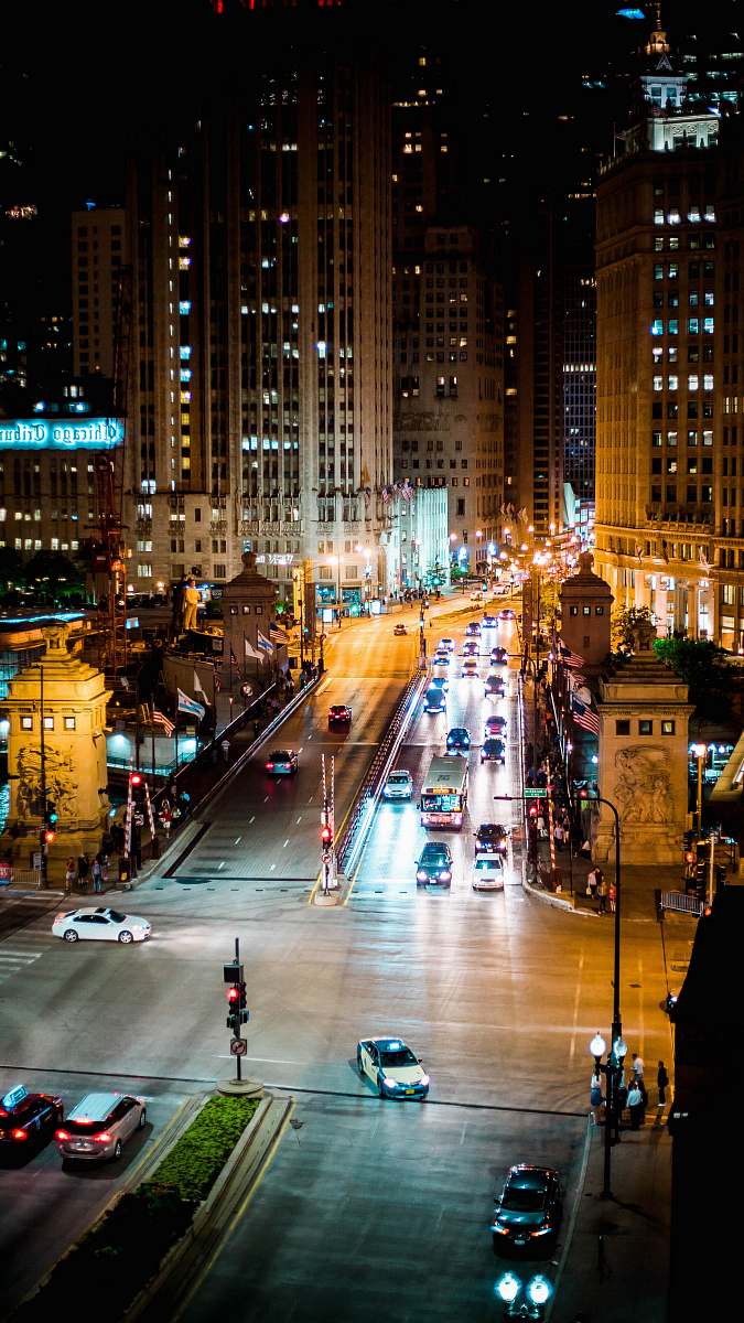 intersection vehicles running on road at night automobile