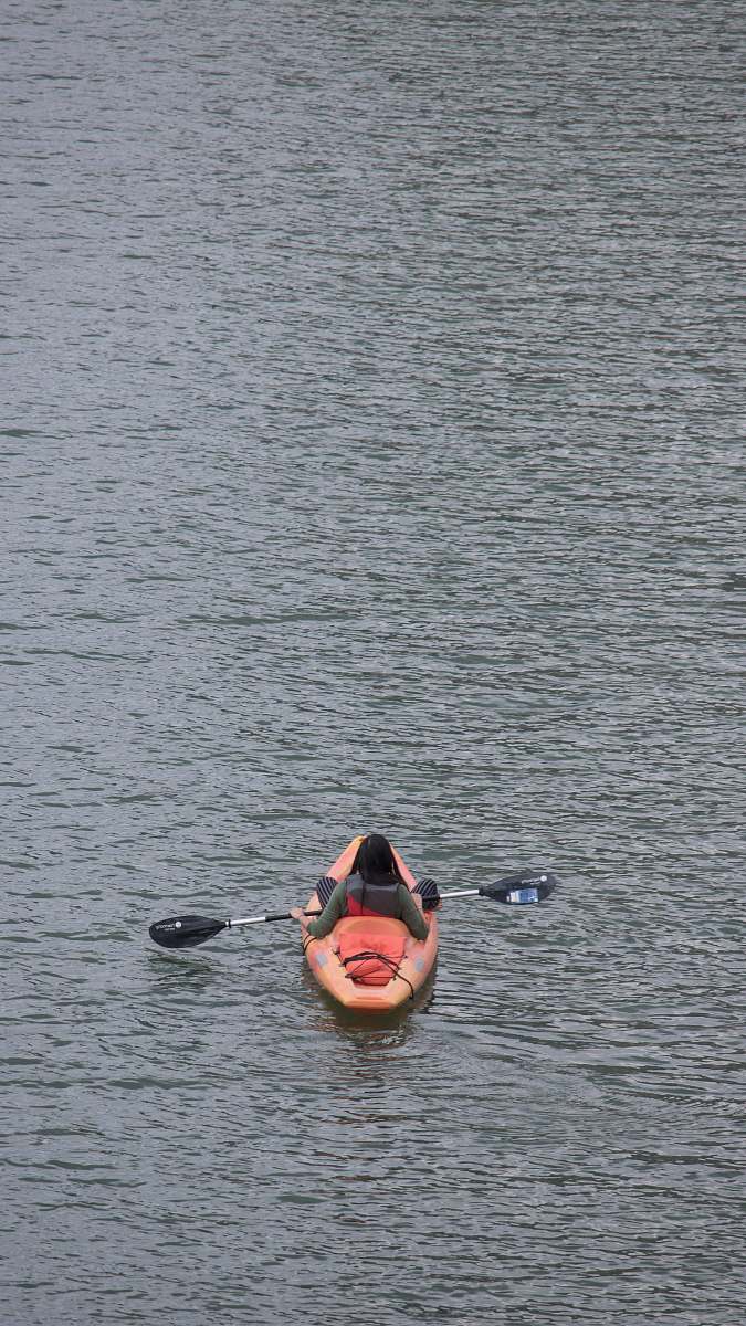 kayak person on kayak on body of water boat