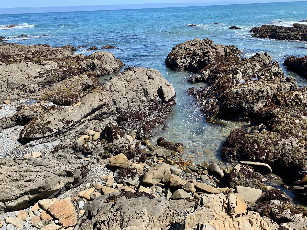 promontory black rock formation beside sea rock