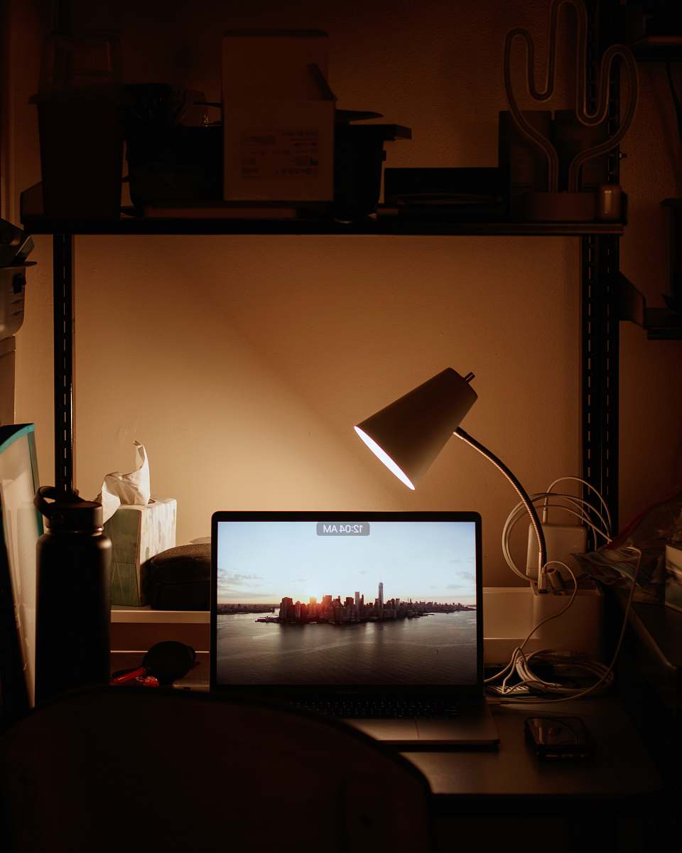 display laptop turned on beside desk lamp turned on electronics