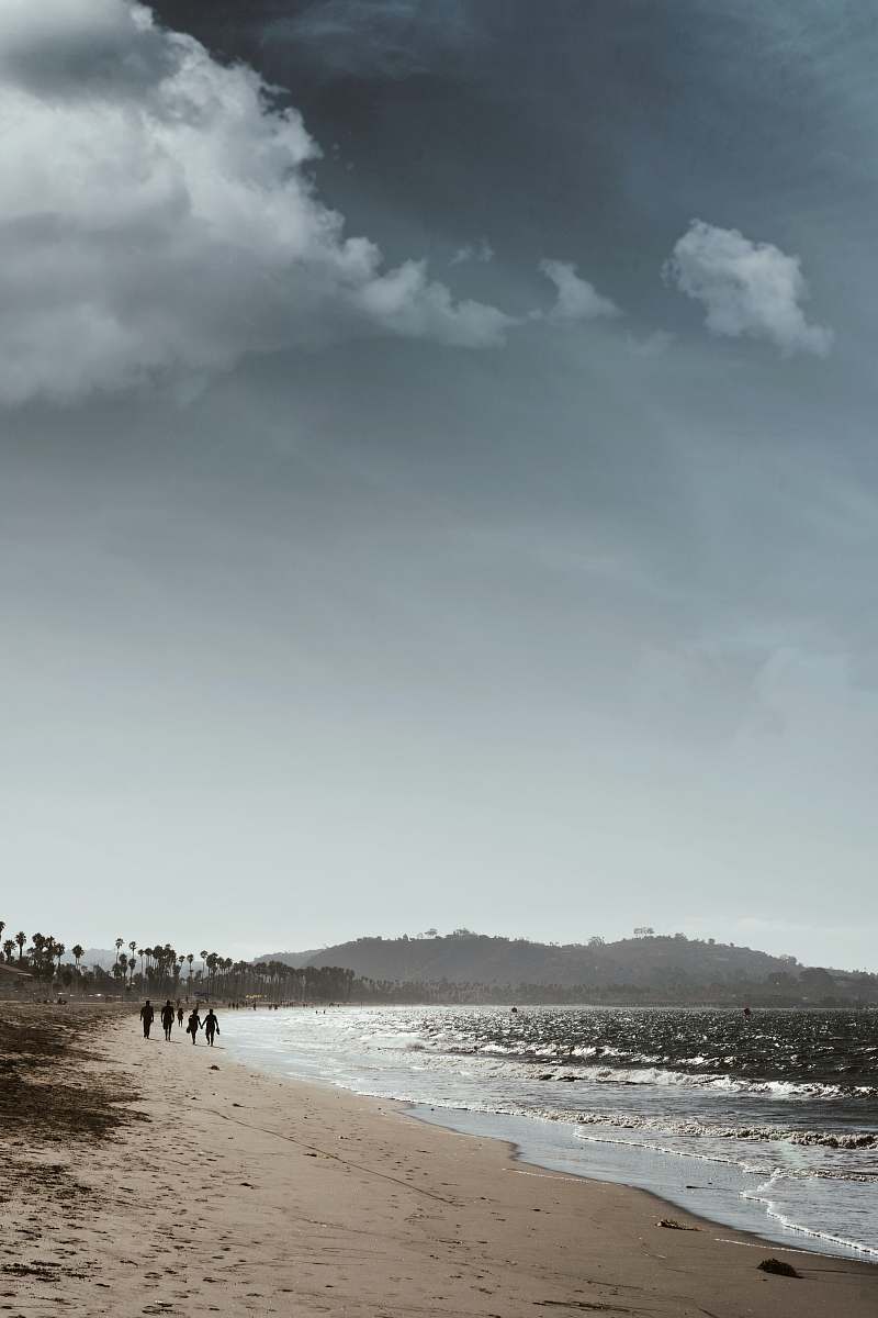 beach people walking near seashore during daytime grey