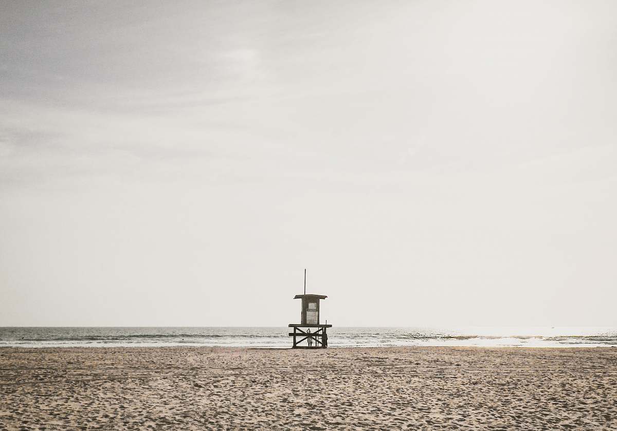 grey photo of lifeguard station near shoreline beach