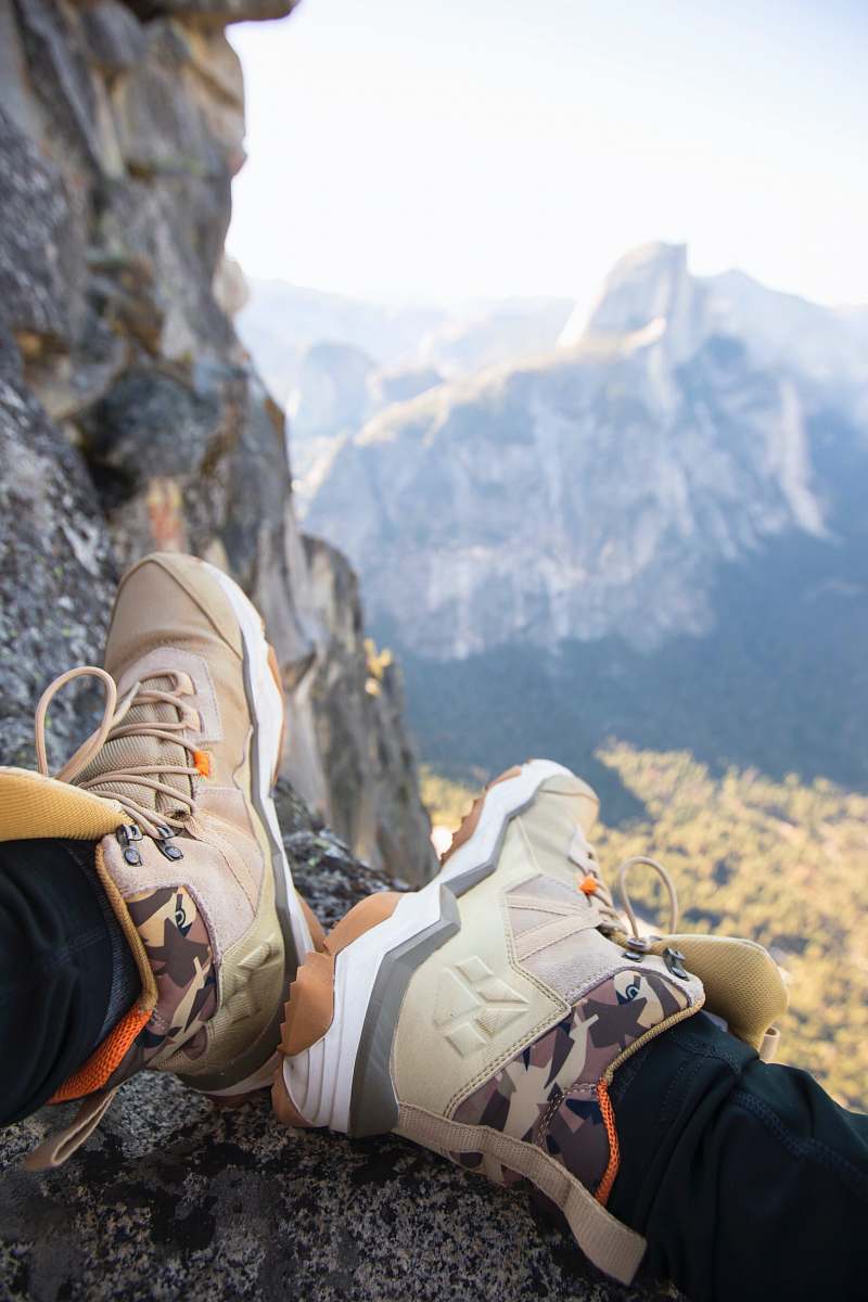 apparel person sitting on rock near gray fault-block mountain clothing