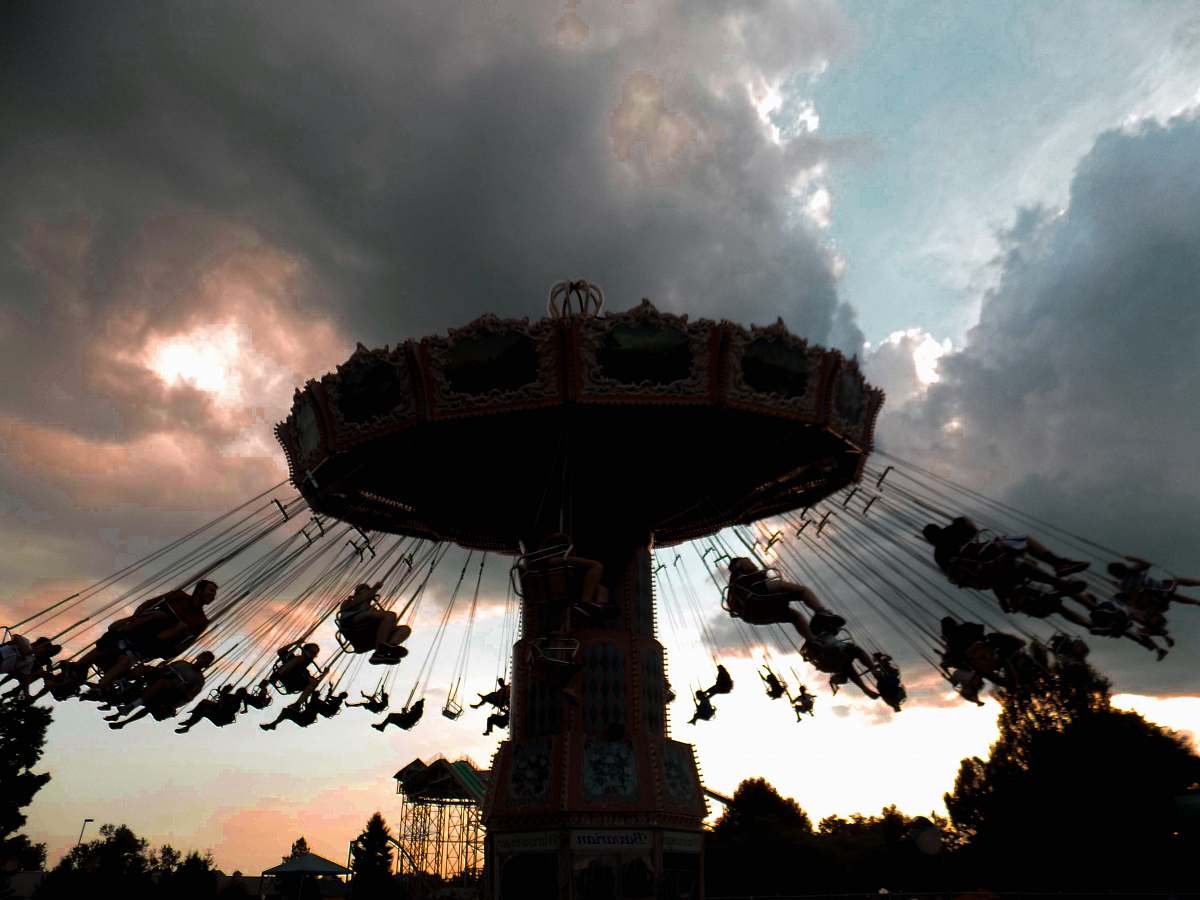 fountain beige carousel under cumulud clouds water