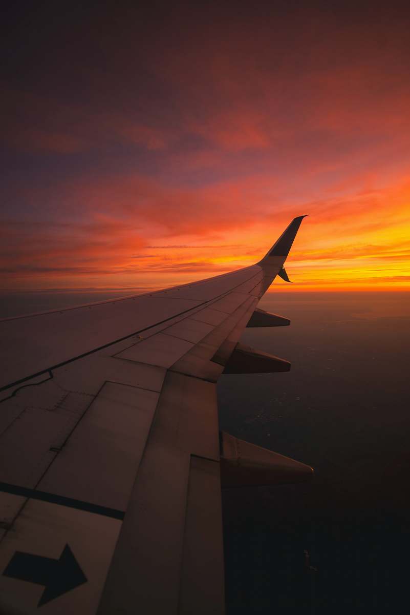 sunset bird's eye view photography of airplane wing sunrise