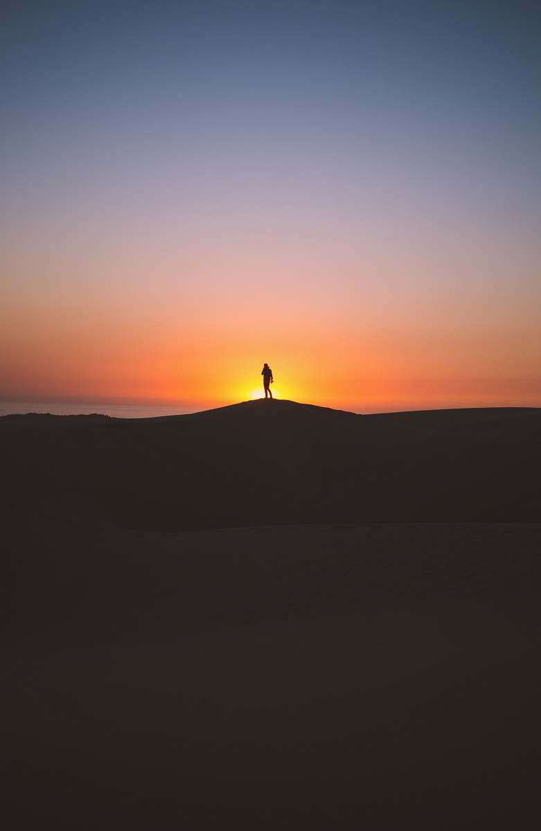 sunset silhouette of person standing on hill sky