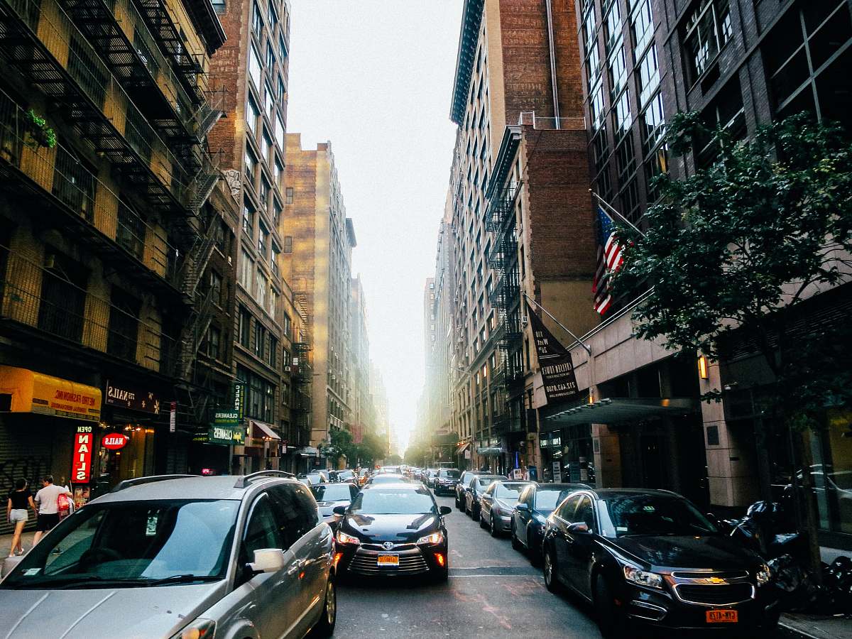 car different vehicles on road viewing city with high-rise buildings automobile