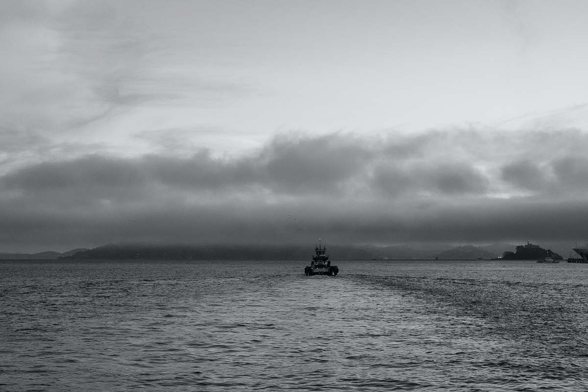 black-and-white grayscale photo of boat on ocean boat
