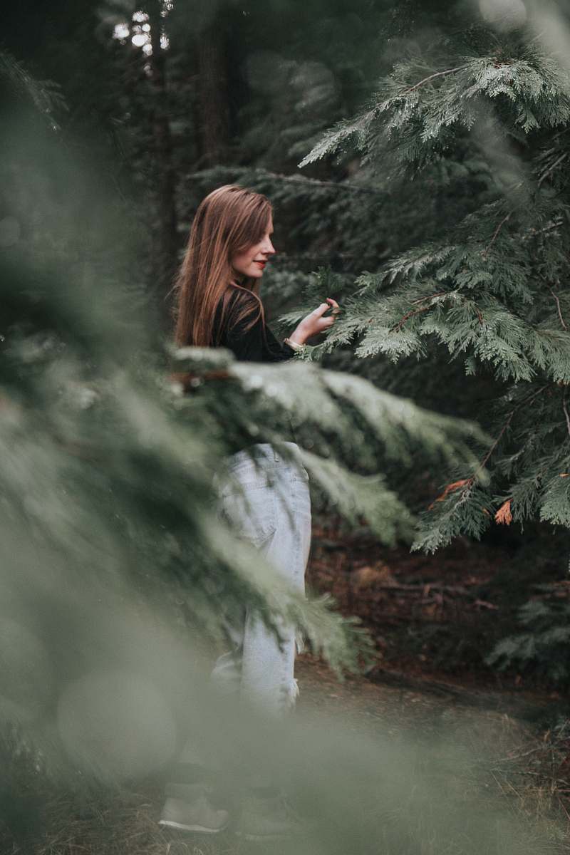 female selective focus photography of woman standing between trees lassen national forest