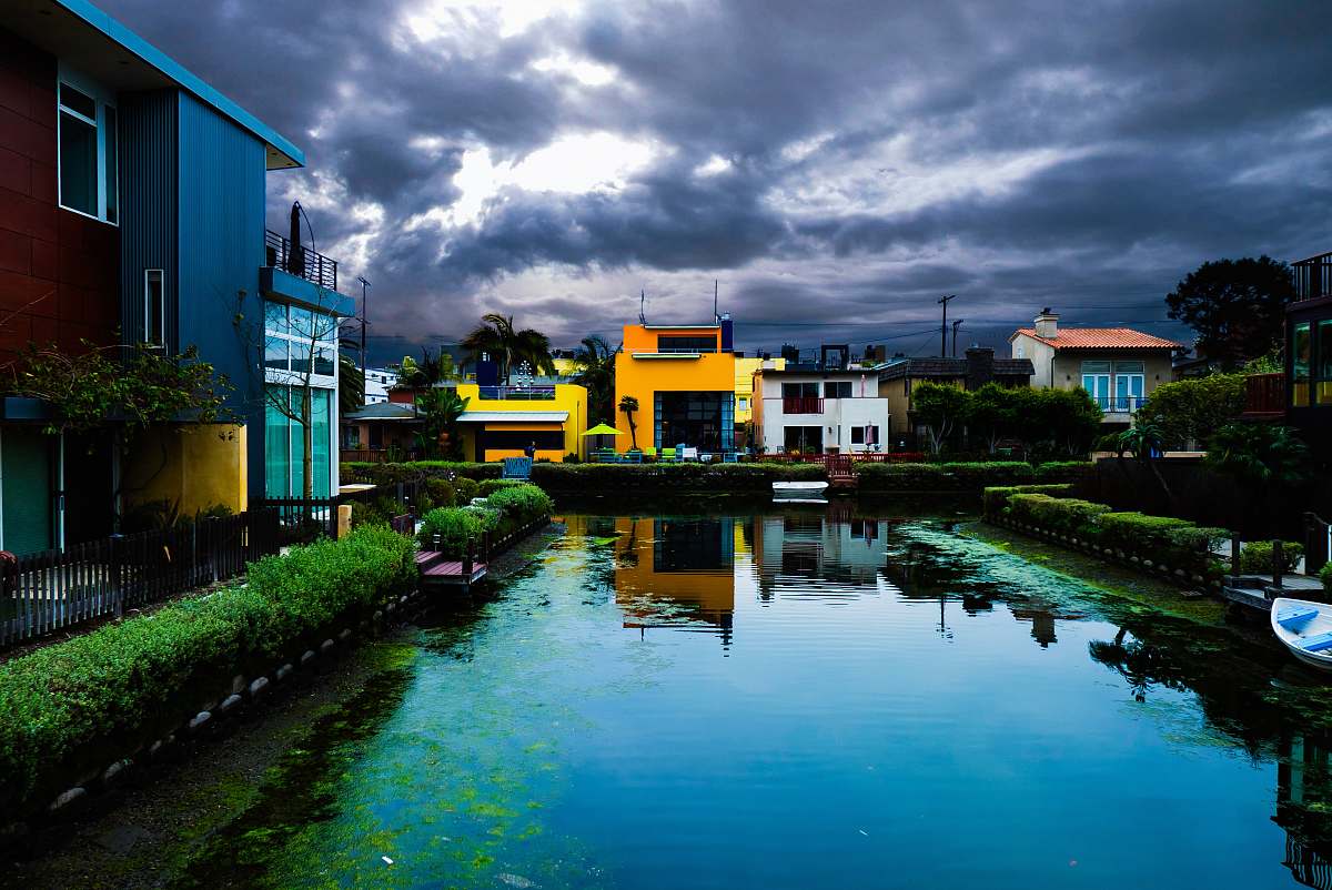 nature buildings near body of water under cloudy sky during daytime outdoors