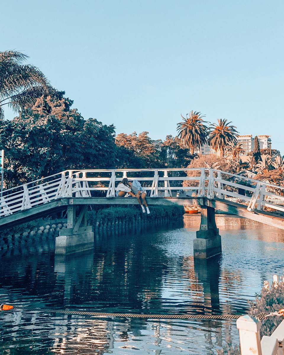 bridge couple kissing on top of gray and white metal bridge venice canals