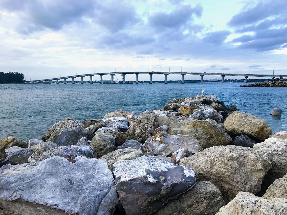 waterfront gray rocks near body of water under cloudy sky during daytime dock