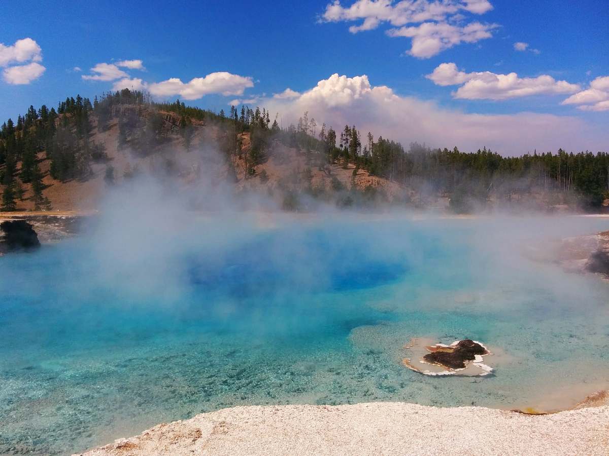 mountain hot spring near trees under cloudy sky at daytime nature