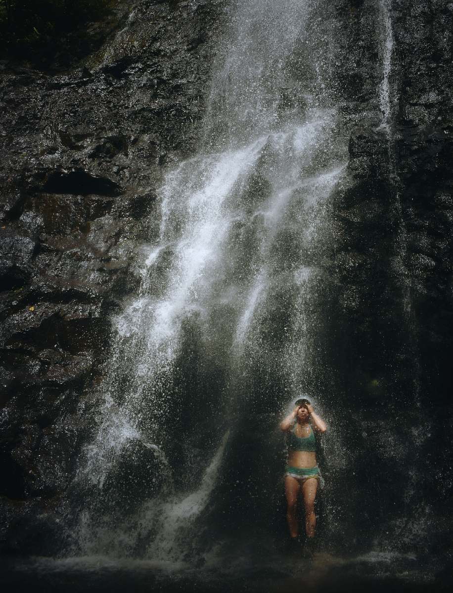 grey woman taking a bath in waterfalls ka‘au crater