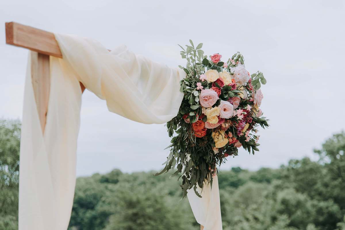 flower bouquet of assorted-color flowers hanged on brown plank with white textile flora