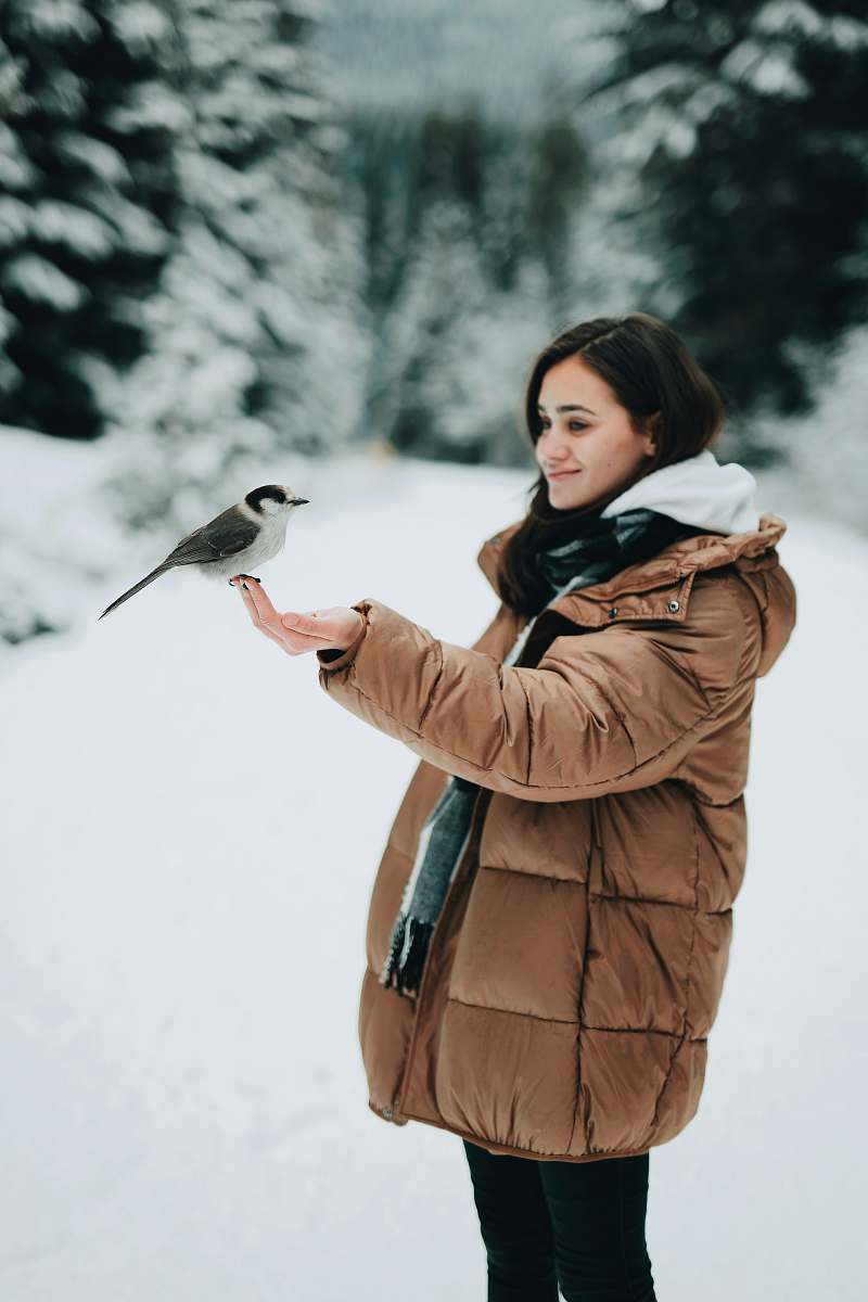 animal woman holding black and white bird apparel