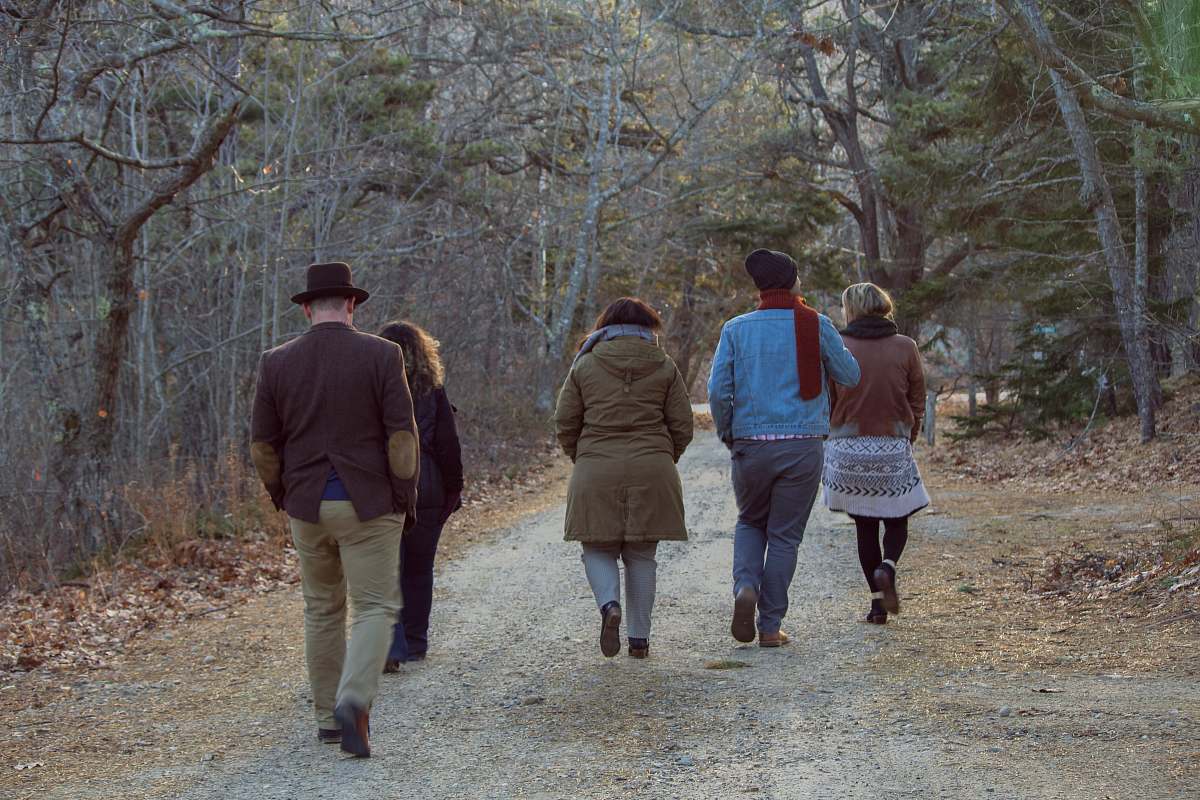 clothing five people walking between trees shoe