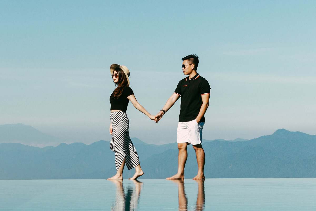 clothing man and woman walking near mountains shorts
