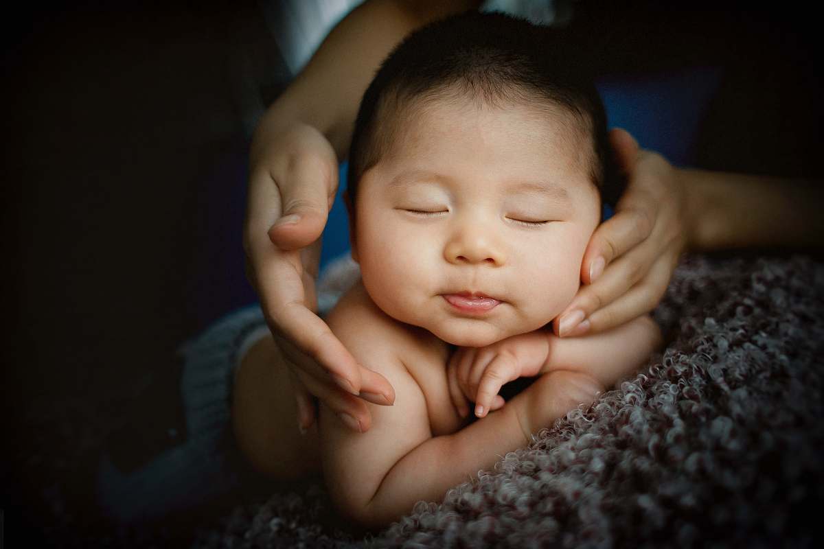 people baby lying on gray textile kid