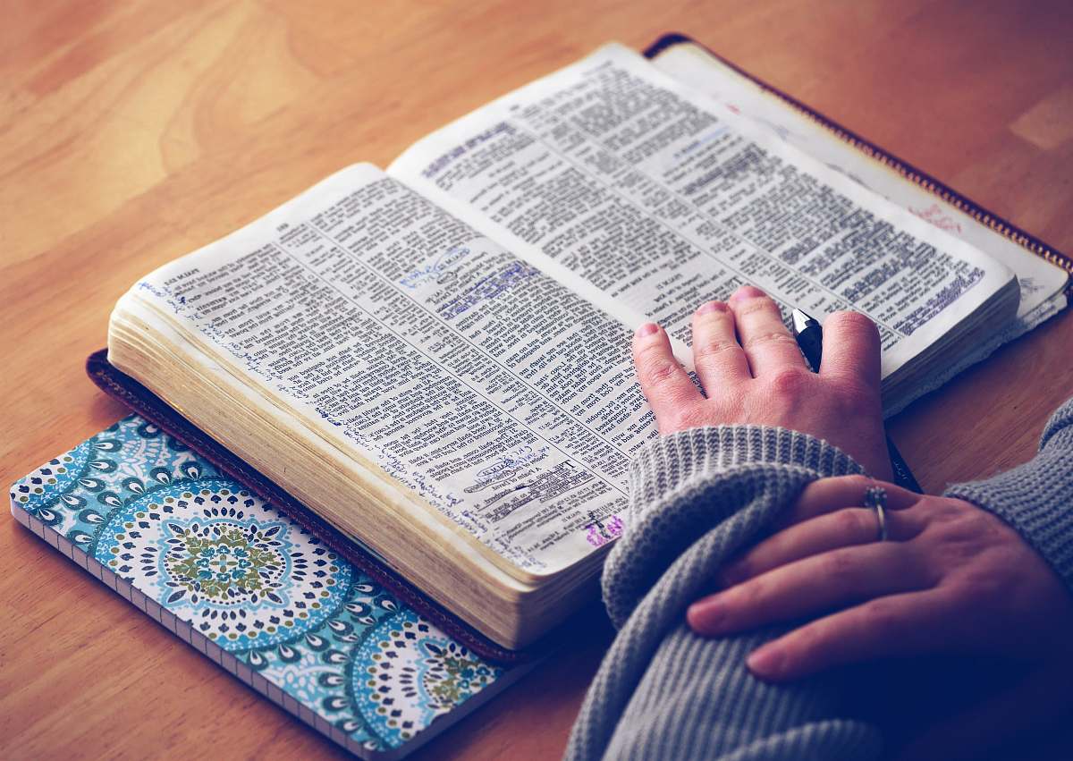study person reading a book with hands on top of book notes