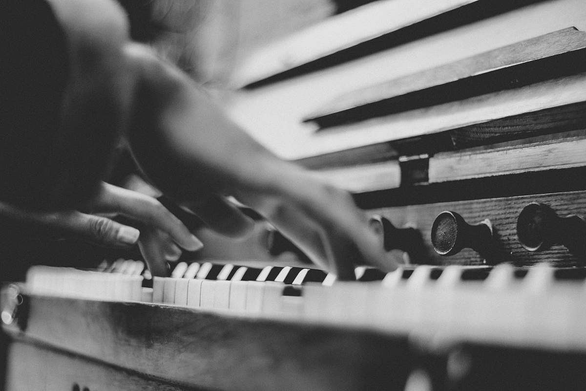 grey gray scale photo of person playing piano music