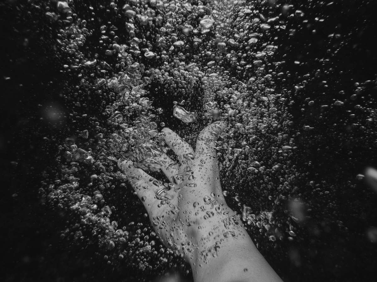black person's arm under water with frizz water