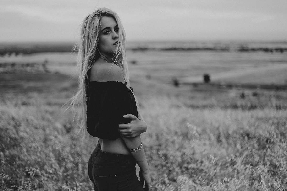 woman woman in black off-shoulder crop-top standing on grass field girl