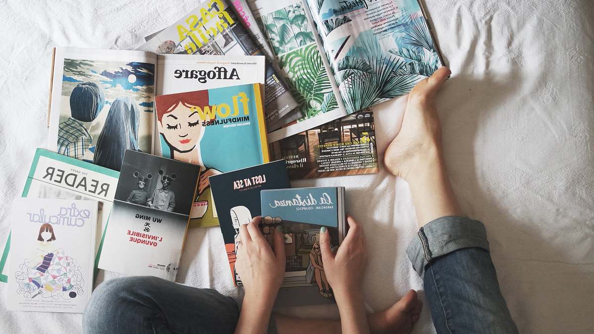books person holding blue book magazines