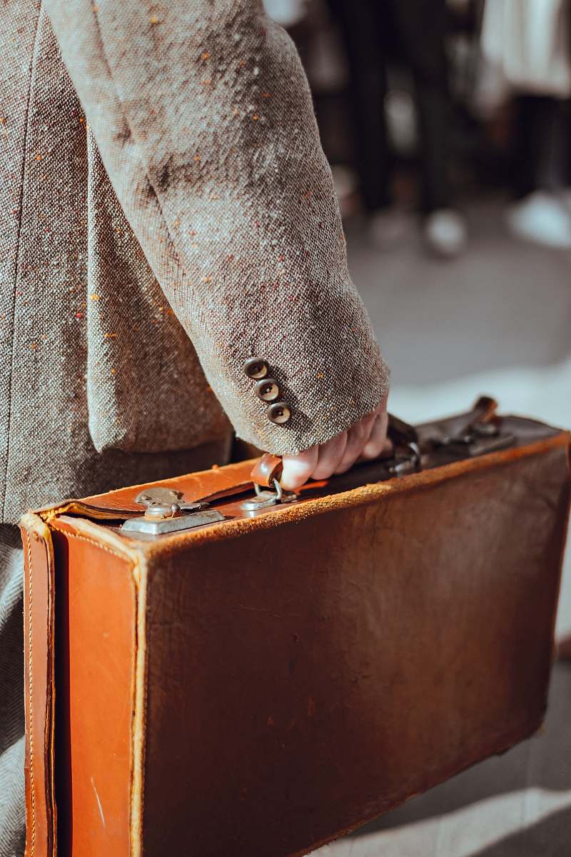 leather person wearing coat carrying suitcase carry