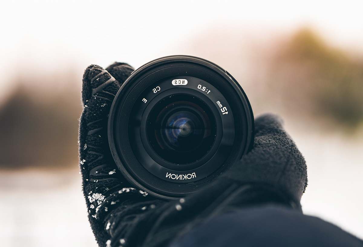 electronics person holding Rokinon zoom lens camera lens