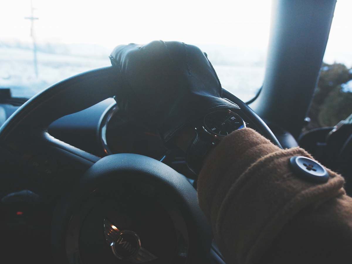 cushion person holding black steering wheel grey