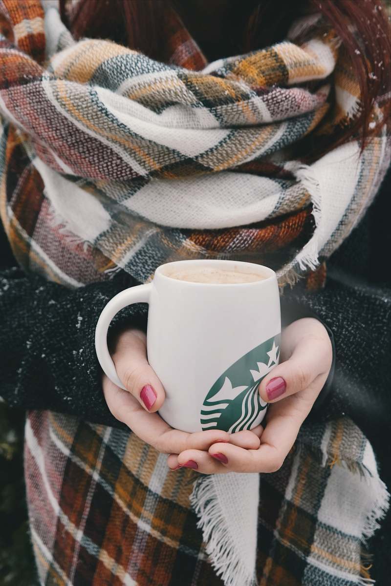 cup person holding white and green Starbucks ceramic mug mug