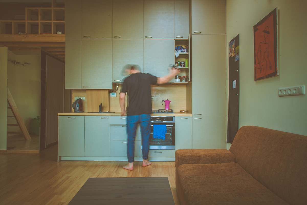 kitchen man facing on gray wooden cabinet picking container room
