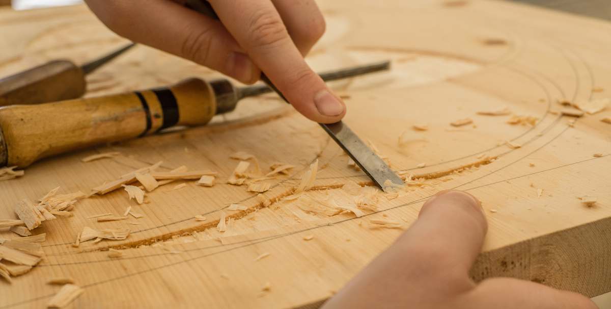 wood person using chisel while curving wood crafting