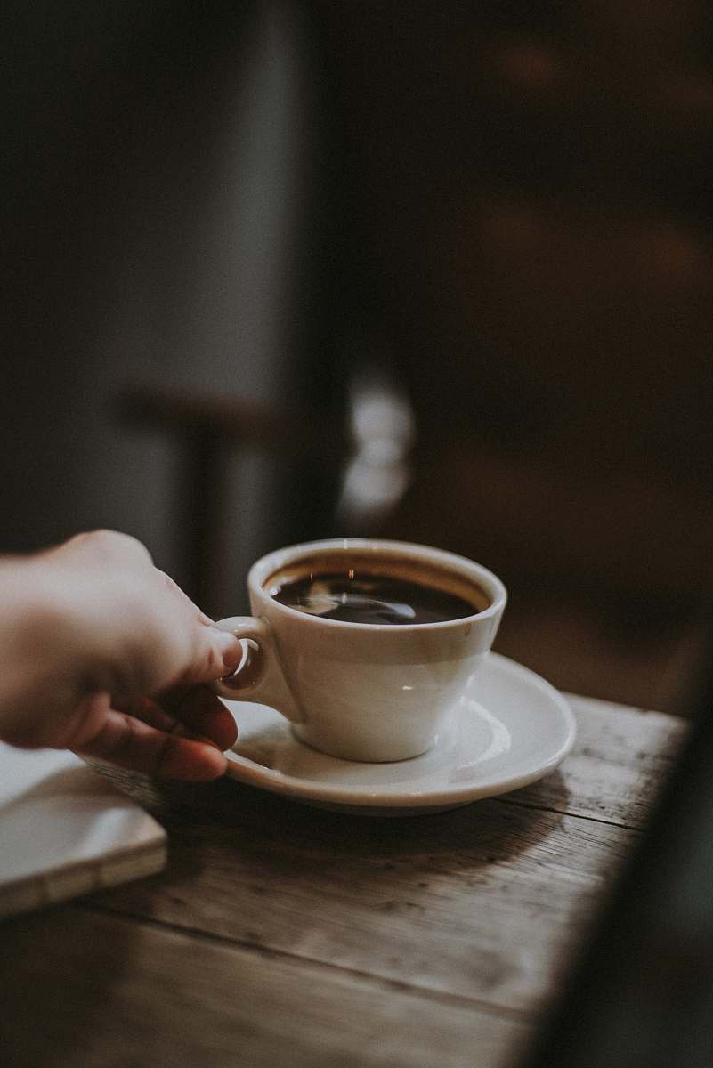 coffee person holding white ceramic cup with liquid coffee cup