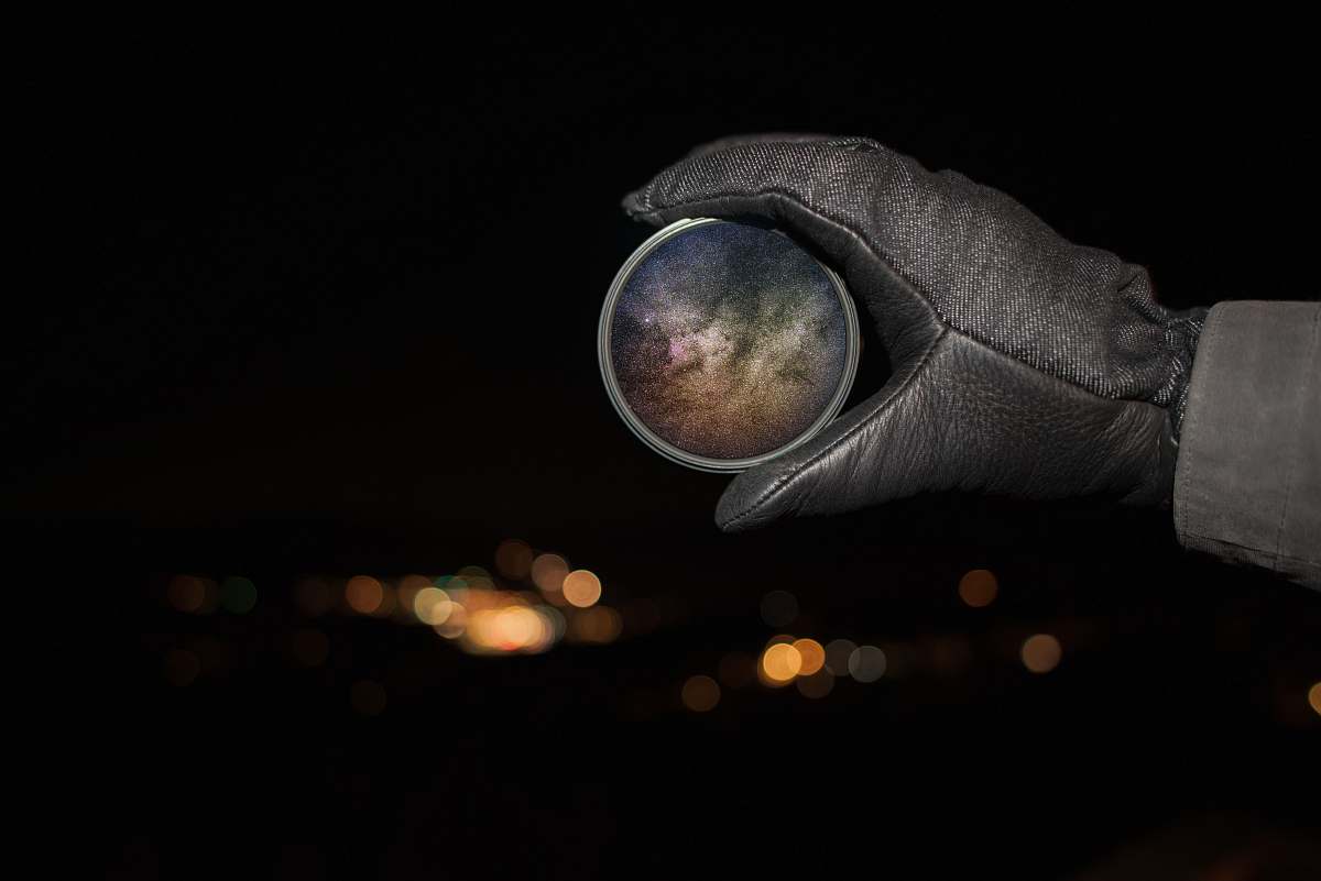 stars person holding round gray device night