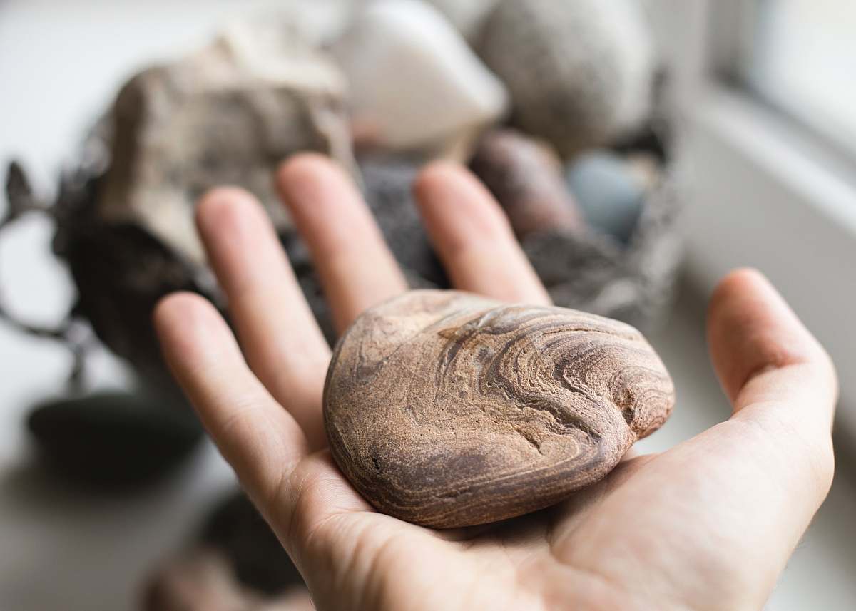 human brown stone on palm person