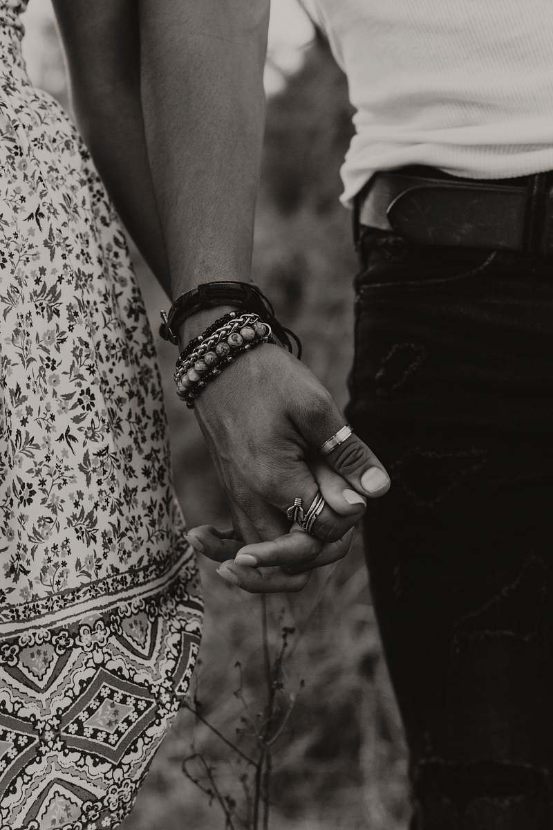 person gray-scale photo of woman and man holding hands human