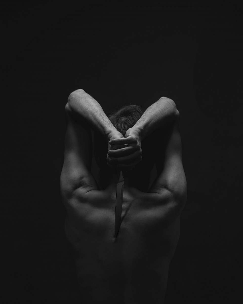 hand grayscale photography of person holding knife black-and-white