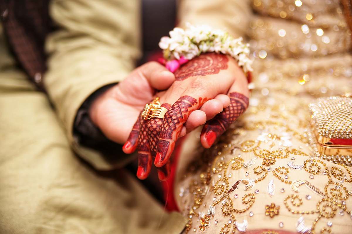 hand person holding hands wearing gold-colored ring henna