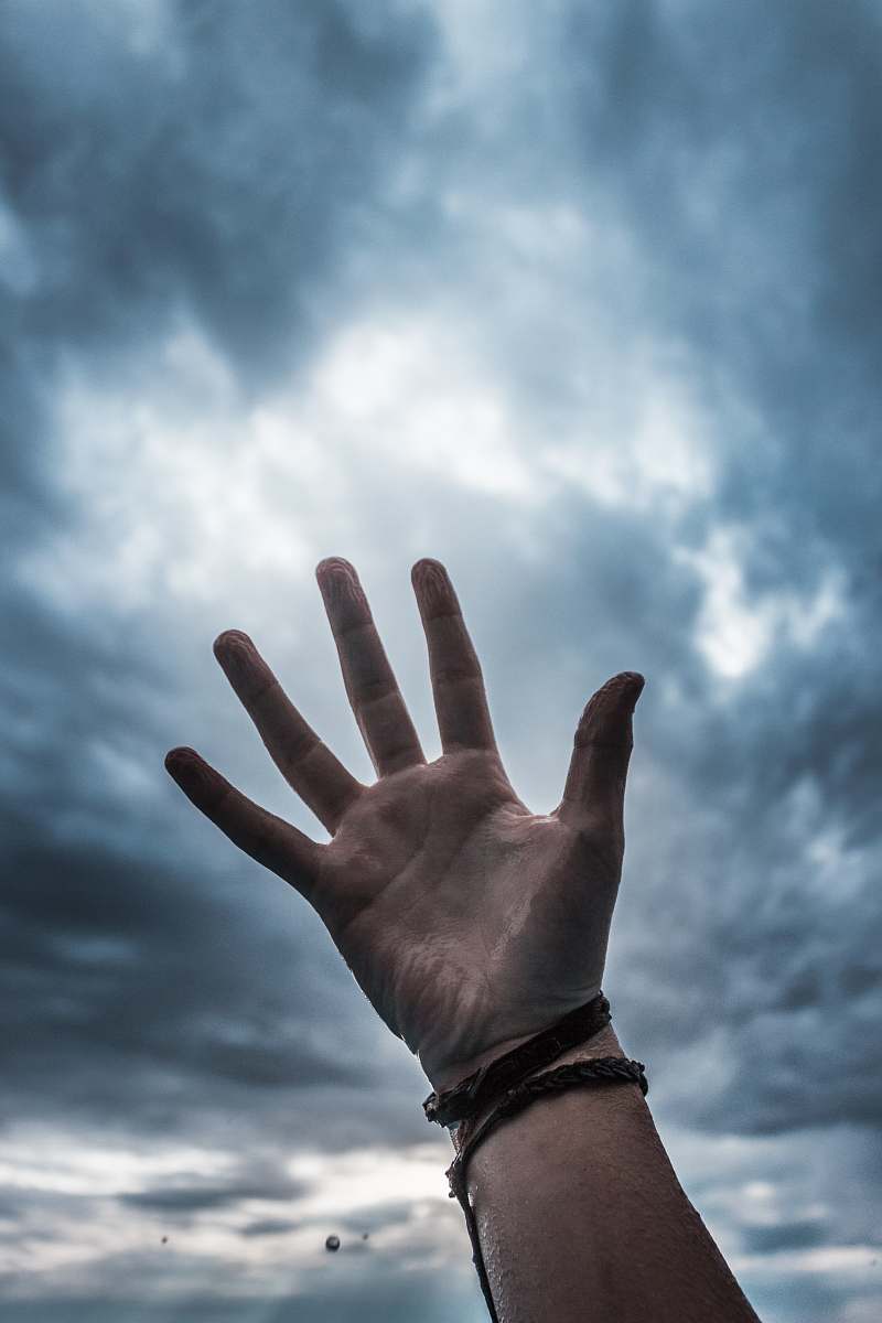 human person raising hand into the sky person