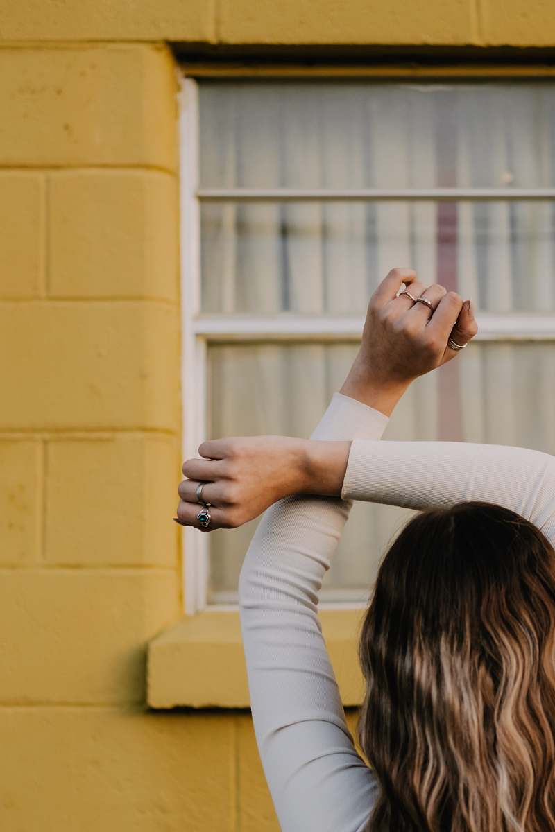 human woman standing in front of building's window person