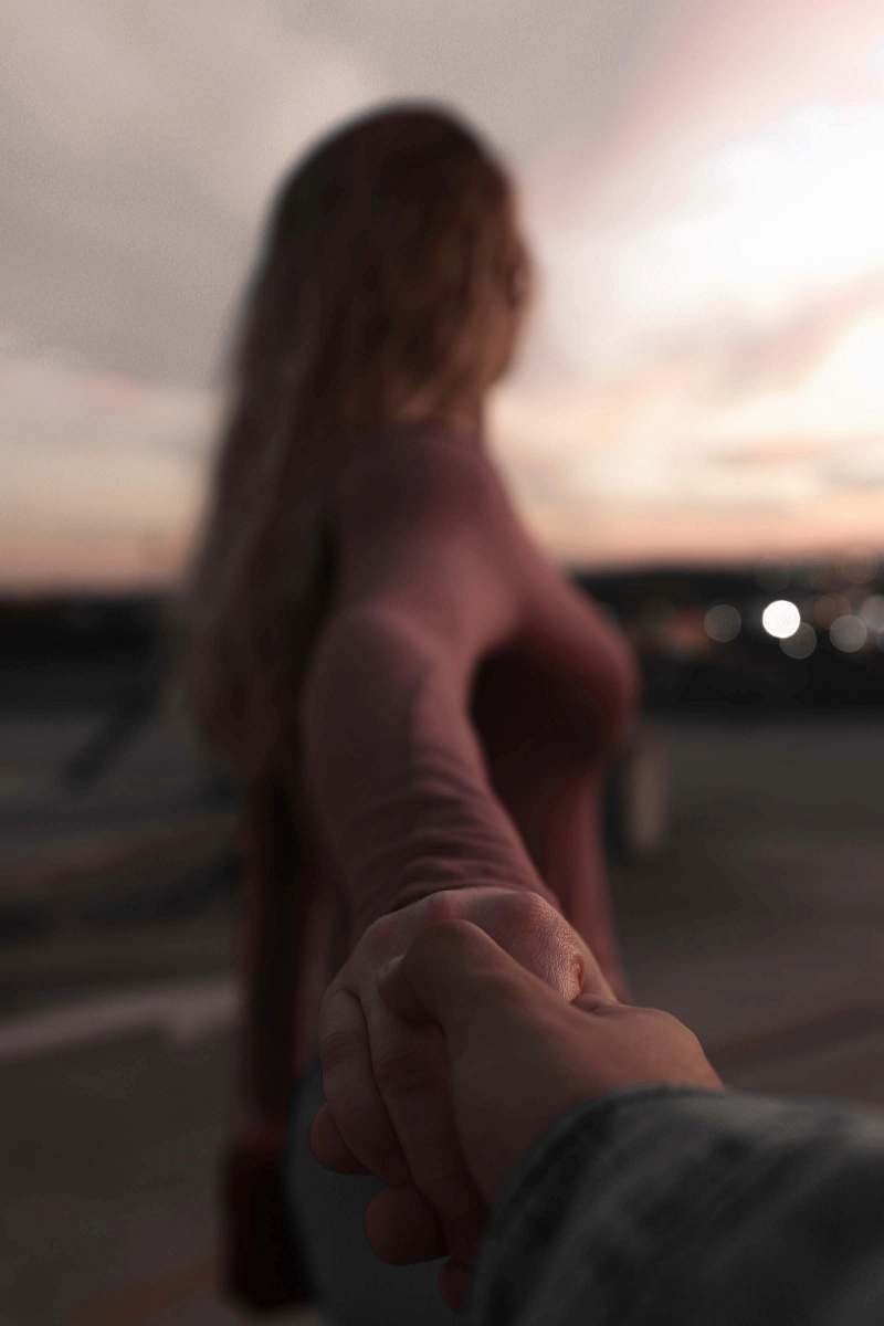human woman walking in front while holding hands person