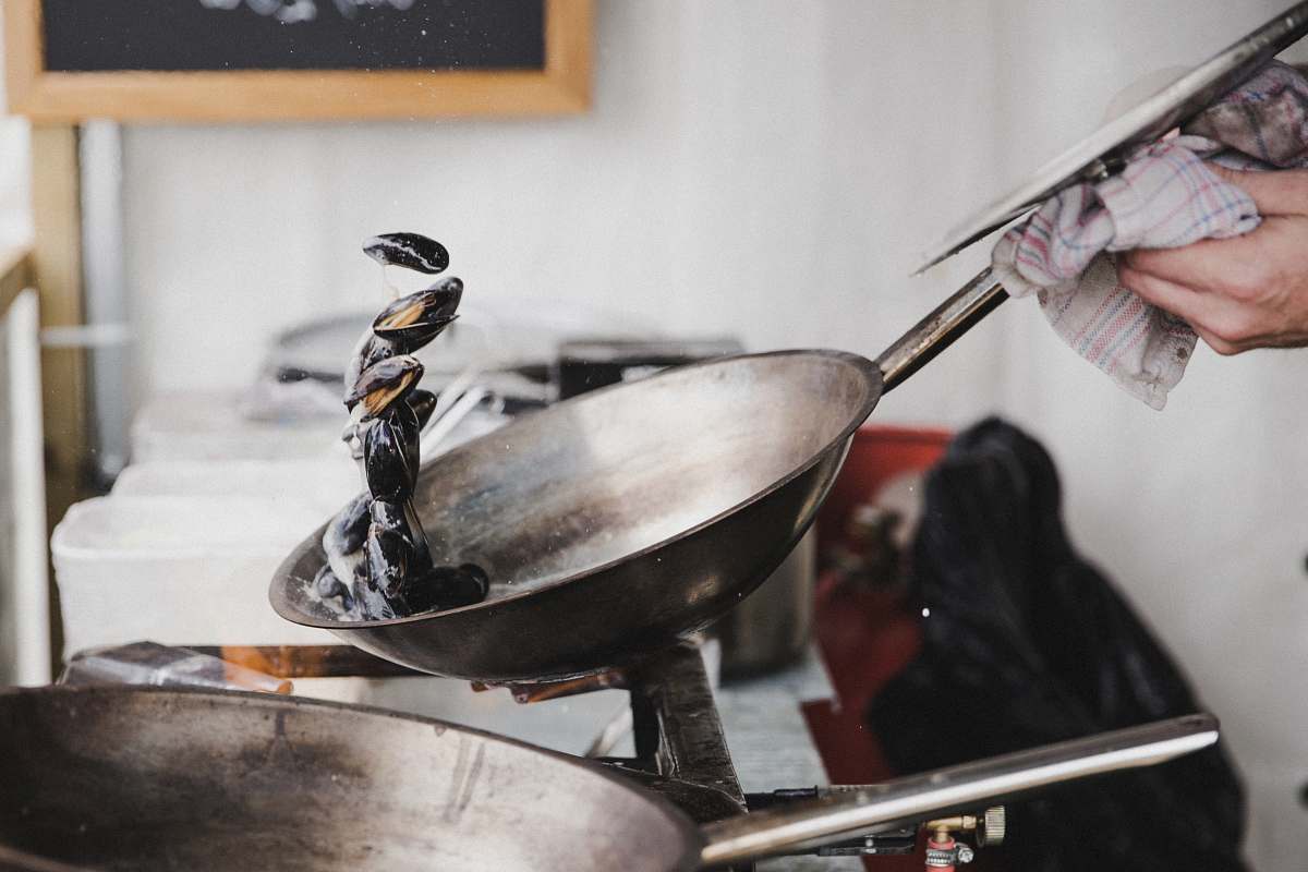 cooking person holding gray cooking pan pan