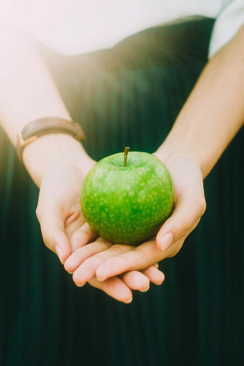 fruit person holding green apple apple