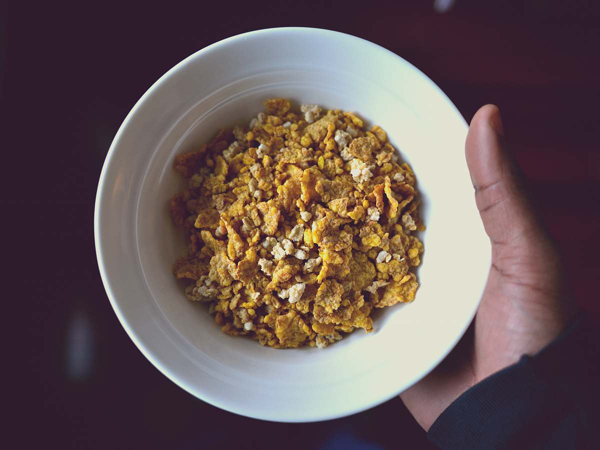 bowl person holding white ceramic bowl filled with cereal cereal