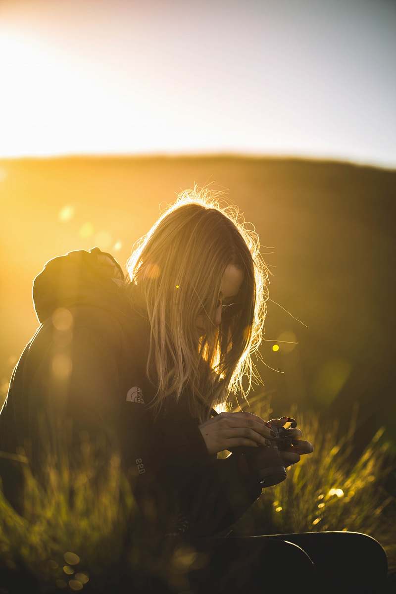 woman woman in black jacket holding black DSLR camera sunlight